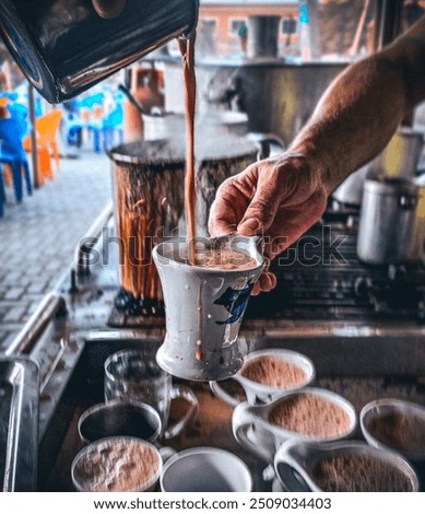 Capturing the authentic tea-making experience at the iconic Quetta Hotel in Pakistan, this photograph showcases a skilled tea maker expertly pouring hot, freshly brewed chai into a traditional cup.