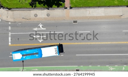 Capturing a bird's eye view of a section of street as a public bus navigates the city.