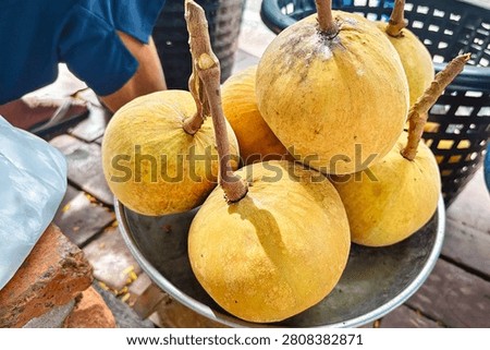 Capturing the fun of roadside shopping, with fresh Santol on a scale, emphasis is natural colors and appetizing textures. 