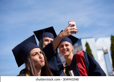 Capturing A Happy Moment.Students Group  College Graduates In Graduation Gowns  And Making Selfie Photo