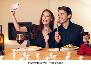 Capturing Moments. Beautiful Lovely Excited Young Couple Taking Selfie While Sitting At Table And Having Dinner. Smiling Woman And Man Eating Pasta, Making Photo, Having Fun At Restaurant Or At Home