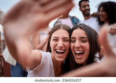 Capturing moments. Portrait of two Caucasian beautiful girls making photo frame with hands looking camera and smiling excited for selfie outdoor. Happy young women gesturing for picture at party.  - Powered by Shutterstock