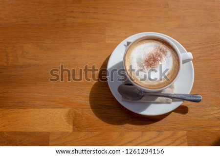 capucinno cream on top of coffee cup on wood table from top view Fresh up life in your day with hot coffee.