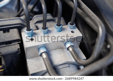 Car ABS module with connected hydraulic brake lines close-up view