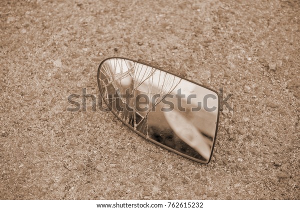 car accident, broken\
mirror on the road