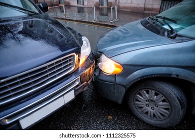 A Car Accident In The City In Rainy Weather Between A Minivan And An SUV. General Form.