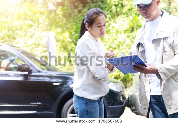 Car
accident Car crash The woman talking to  Insurance agent about the
accident. Insurance agent writing document on clipboard of the
incident for claim process. Transportation
concept.