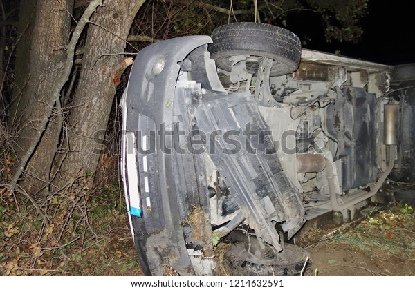 Car accident. The car\
crashed on the road and overturned. Car accident over raining night\
in autumn time.
