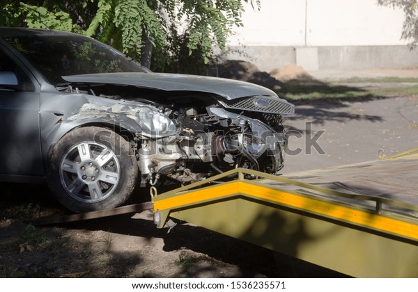 car accident, head-on collision. Tow truck loads\
a wrecked car after an\
accident