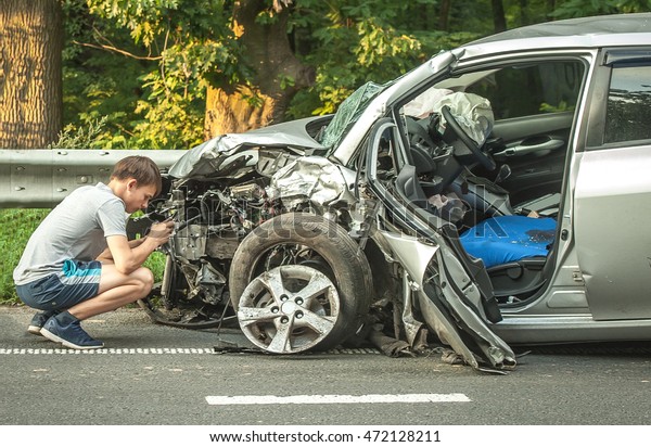 Car accident. The image of\
crashed cars. Driver Arguing After Traffic Collision. schosse\
accident. Man photographing his vehicle with damages for accident\
insurance