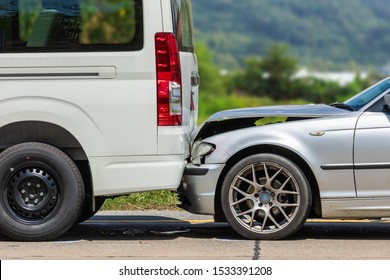 Car Accident Involving Two Cars On The Road. Back Side Of Van And Front Of Siver Car Get Damaged By Accident. For Car Repair Concept