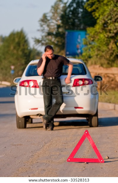 Car\
accident on a road. Focus is on the red triangle\
sign