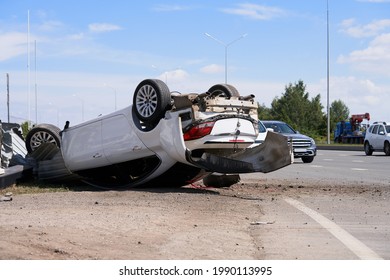 Car accident on the road. The motorist violated the speed limit, did not fit into the turn. The car rolled over, wheels up.                                - Shutterstock ID 1990113995
