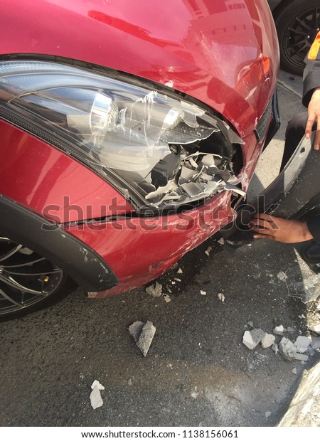 car accident, red car crash with the wall,\
broken headlight