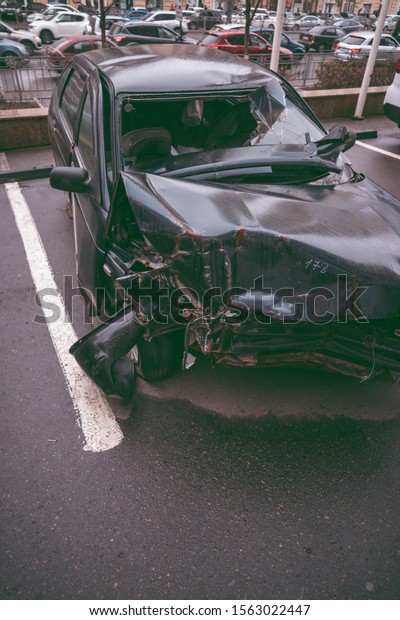 The car after the\
accident. Broken car on the road. The body of the car is damaged as\
a result of an accident.