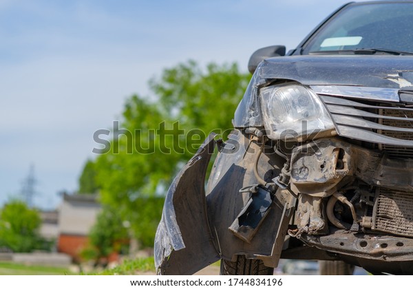The car after the accident.\
Broken car on the road. The body of the car is damaged as a result\
of an accident. Dents on the car body after a collision on the\
highway
