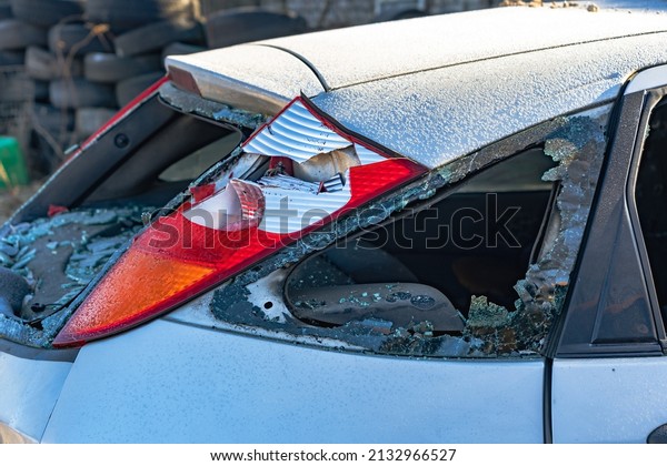 a car after an accident with a broken rear\
window and headlight