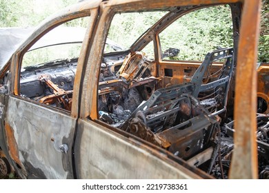 Car After A Fire. Burnt Rusty Car After Fire Or Accident. Car After The Fire, Crime Of Vandalism, Riots. Arson Car. Accident On The Road Due To Speeding. Explosion.