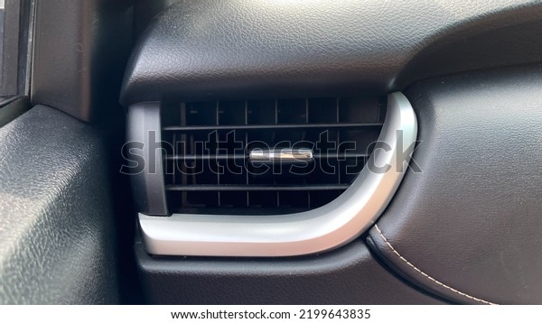 Car air conditioner. Close up\
image of air conditioner inside a car with sunlight at the\
top.