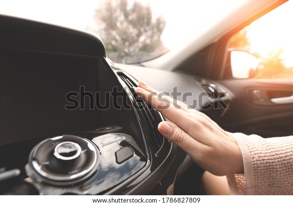Car air conditioning. Woman checks air conditioning\
in a car