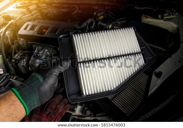 Car air filter is in the hands of a mechanic\
for replacing the dirty air\
filter