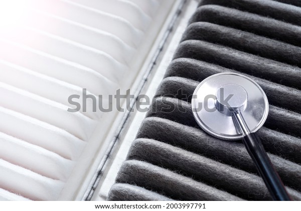 Car air filter - it\
is a lungs of the automobile. Concept with a new and old air\
filters with stethoscope.
