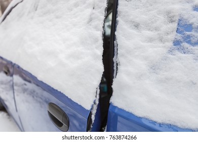 Car With The Ajar Door Is Covered With Snow On The Side