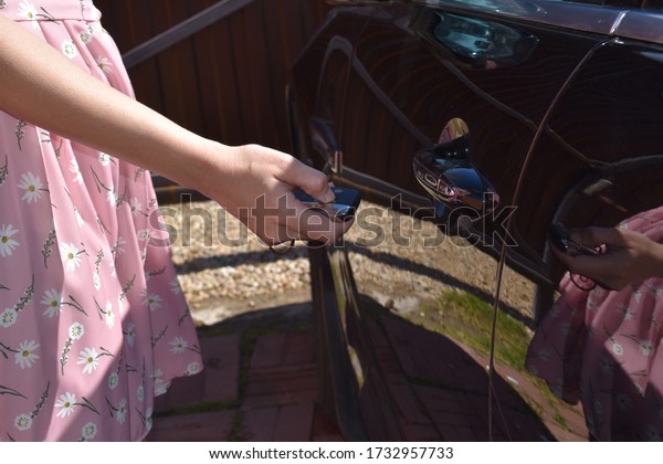 Car alarm. The woman puts the car into guard. The\
owner of expensive car.