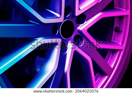 Car alloy wheel texture background in blue and pink tones. New alloy wheel for a car. Modern alloy rim. Car wheel disc.