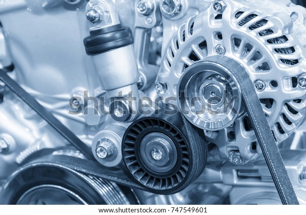 The car alternator in the light blue scene .Close\
up of the  of engine part.