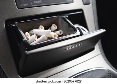 The Car Ashtray Is Filled With Smoked Cigarettes.