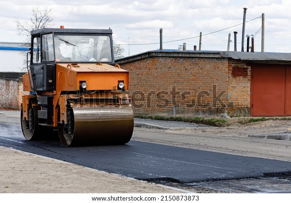 Car for asphalt laying.\
Road construction works with roller compactor machine and asphalt\
finisher.