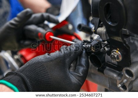 Car assembly tools and dismantled car engine in a car mechanic workshop