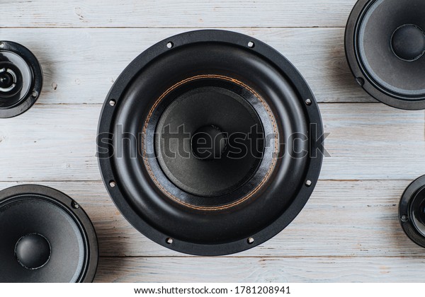 Car audio, car speakers, black subwoofer on a\
white wooden background. Close\
up