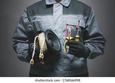 Car Audio Specialist Holding In Hands A Car Audio Equipment On Dark Background.