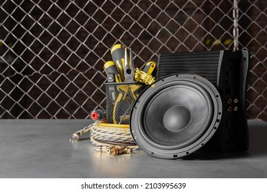 Car audio stereo loudspeaker and sound amplifier on the workbench background front view.
