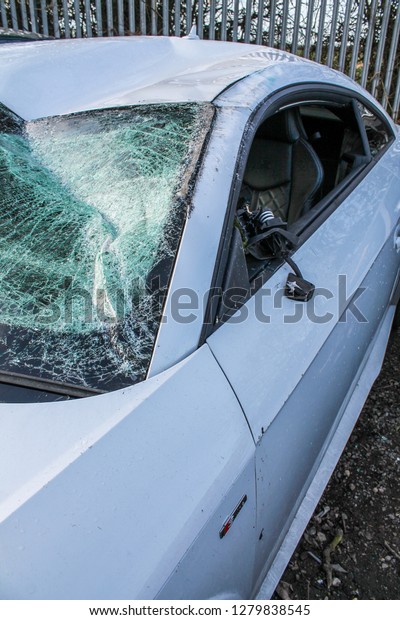 Car / Auto crash; Broken windshield and damaged\
body work. White vehicle.