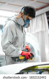 Car, Auto Detailing. Young Auto Mechanic Man Work With The Use Of Orbital Polisher, In Auto Repair Shop, Wearing Uniform, Protective Mask And Gloves