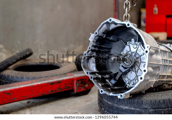 car automatic transmission part\
in repair shop with soft-focus and over light in the\
background