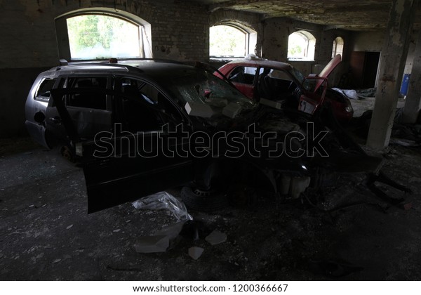 Car\
automobile scrapped salvaged stolen abandoned forgotten in derelict\
concrete building red black grey dark destroyed\
