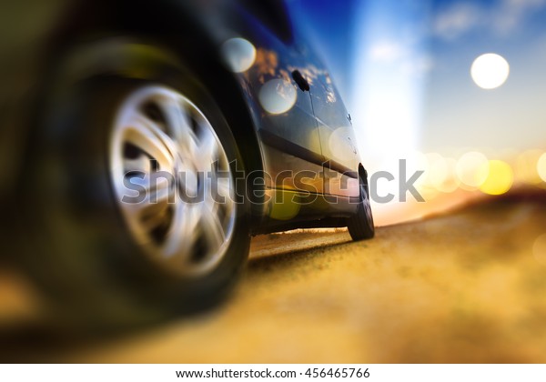 Car and automotive\
concept.Abstract background speed in auto.Tire and wheel in the\
road. Driving fast.Trip and road .Drive in scenery sunset.Car\
wheels and tire  detail. 