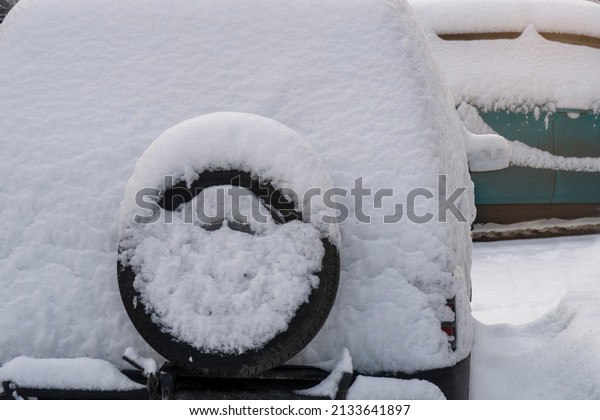 Car back with spare wheel at parking lot in snowy
winter season.