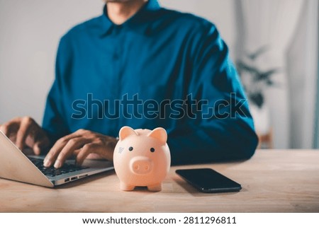 car bank learning e education financial online money internet savings help person save for elearning courses using laptop computer with pink piggy bank and smartphone on desk.