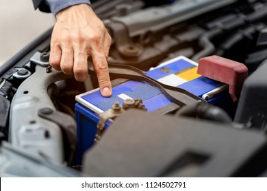 Car Battery Is Dead And Need To Jump Before Driving To Garage For Changing. Man's Hand Pointing On Car Battery, Ask Technician To Change Because Of Low Voltage Level.