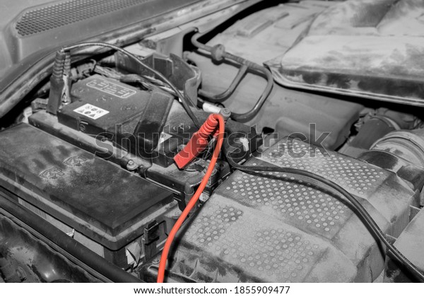 car\
battery and jump leads, selective color\
closeup