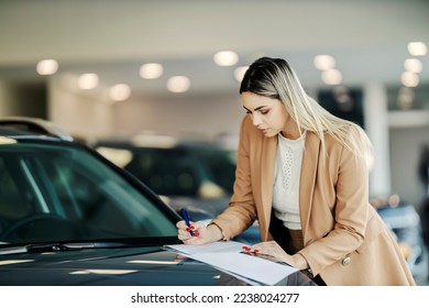 A car bayer is singing up contract while standing at the car showroom.