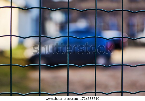 Car behind the\
fence net. Parking, fine\
area.