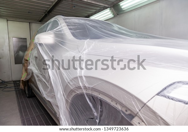 The car is a\
beige color covered with a transparent film to protect against the\
ingress of dirt and splashes from paint during body repair in the\
workshop for painting\
vehicles