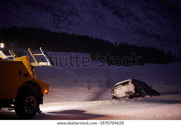 Car being towed\
after accident in snow\
storm