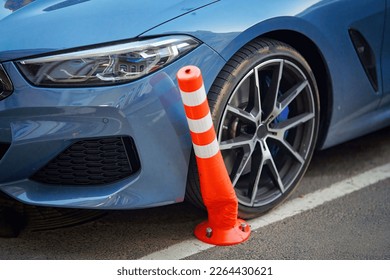 Car bent flexible post while parking on crowded parking lot, selective focus. Car damaged flexible bollard on parking stalls. Bendable bollards can withstand vehicle collisions without losing shape